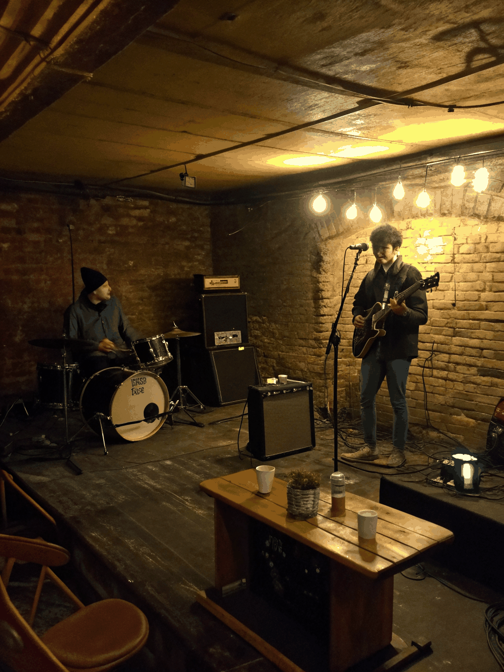 A local band tracking live in a gritty studio with warm mustard lighting