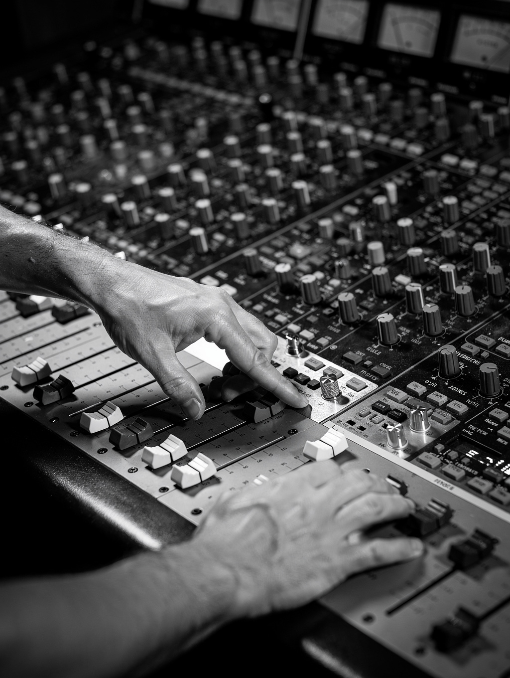 Engineer adjusting levels on a vintage console